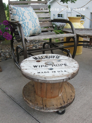 A recycled wire spool becomes a beautiful table for the patio.